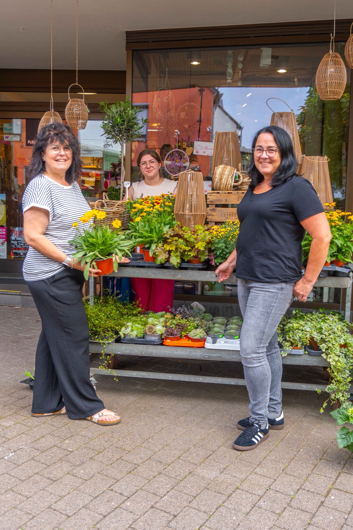 Team von Blumen & Geschenke Thömmes am Pflanzenwagen vor dem Laden