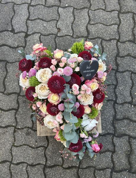 Herzgesteck mit pastellfarbenen Rosen und Dahlien