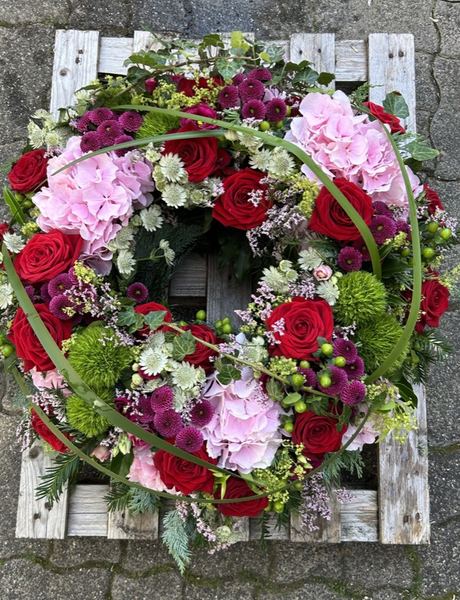 Trauerkranz mit roten Rosen und rosa Hortensien