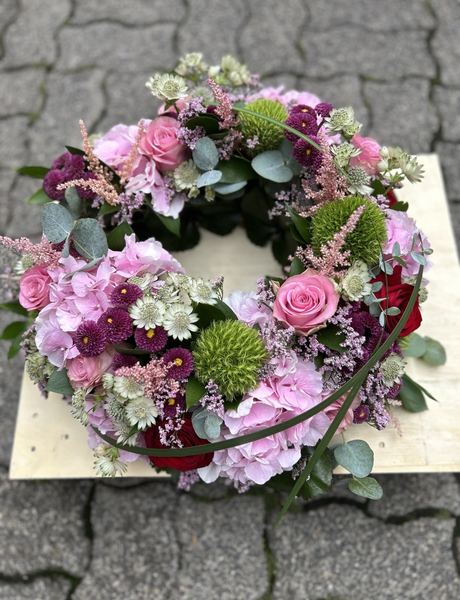 Trauerkranz mit pinken und lilafarbenen Blüten