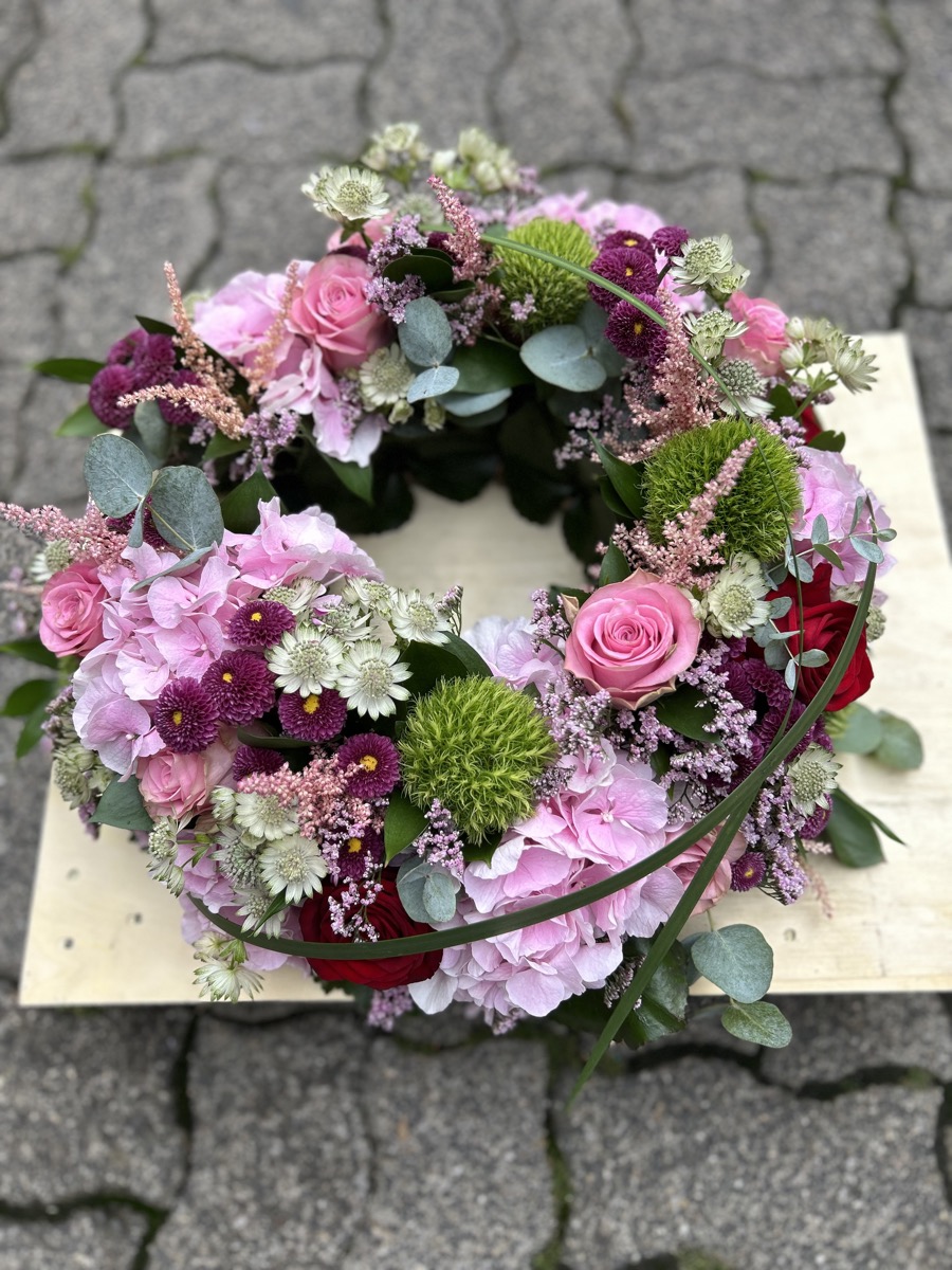 Trauerkranz mit pinken und lilafarbenen Blüten