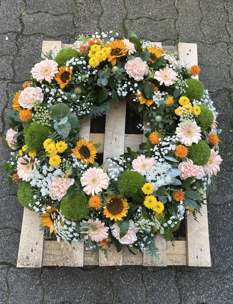 Trauerkranz mit Sonnenblumen und rosa Gerbera
