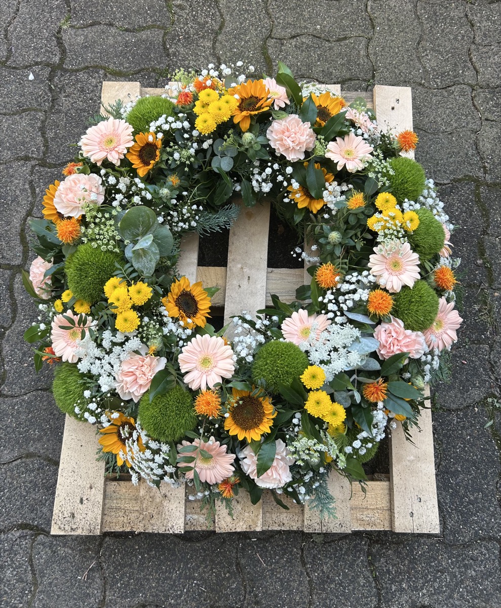Trauerkranz mit Sonnenblumen und rosa Gerbera